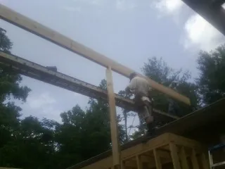 Carpenter setting a ridge beam over a new addition frame — Ice Dam Removal by Roofing Brothers in Palmyra